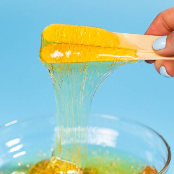 depilation and beauty concept - sugar paste or honey wax for hair removing spatula with wooden framing sticks.